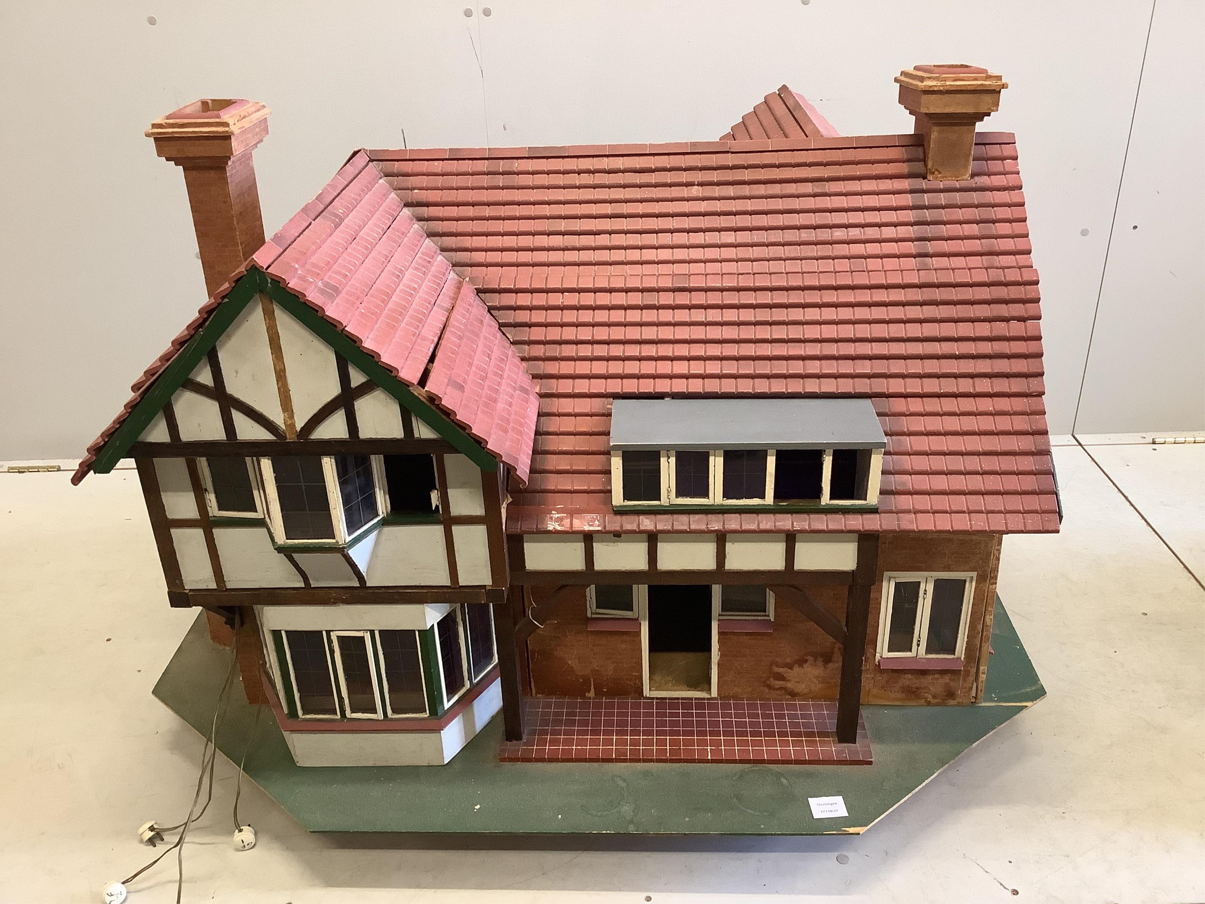 A mid 20th century scratch built mock Tudor doll’s house with some accessories, width 120cm, height 76cm. Condition fair.